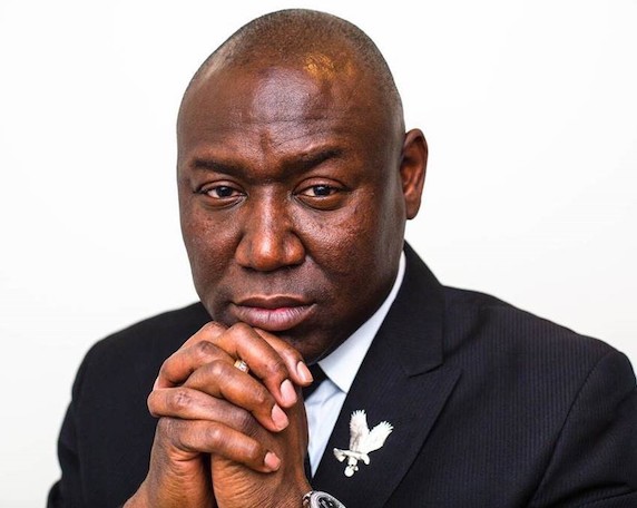Portrait of Ben Crump, staring into the camera with his hands folded in front of his chest